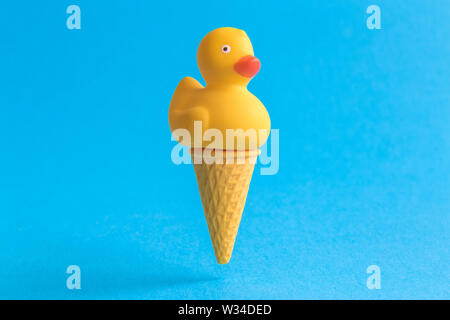 Eis mit Rubber Duck gegen Pastell-blaue Hintergrund minimal Sommer süße Speisen kreatives Konzept. Stockfoto