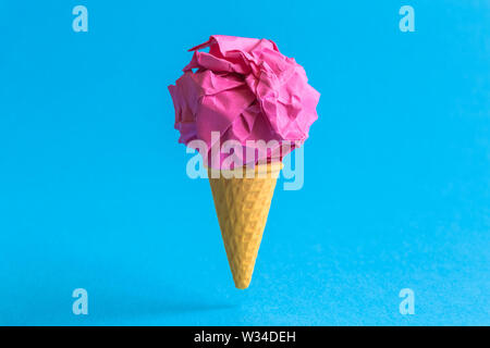 Eis mit zerknittertem Papier in Form von Schaufel gegen Pastell-blaue Hintergrund minimal Sommer süße Speisen und Recyceln kreatives Konzept. Stockfoto