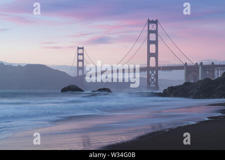 Klassischer Panoramablick auf die berühmte Golden Gate Bridge von der aus gesehen Landschaftlich schöner Baker Beach in schönen goldenen Abendlicht auf einem Sonnenuntergang mit blauem Himmel und Wolke Stockfoto