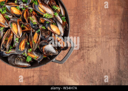 Marinara Muscheln in einem kochenden Topf gekocht, auf einem dunklen Hintergrund im Landhausstil mit einem Platz für Text, Overhead Nahaufnahme Stockfoto