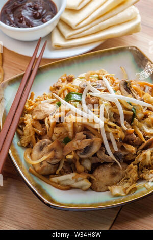 Chinesisches Essen Moo shu Schweinefleisch mit Mandarin Pfannkuchen Wrapper und schwarze Bohne hoisin Soße Stockfoto