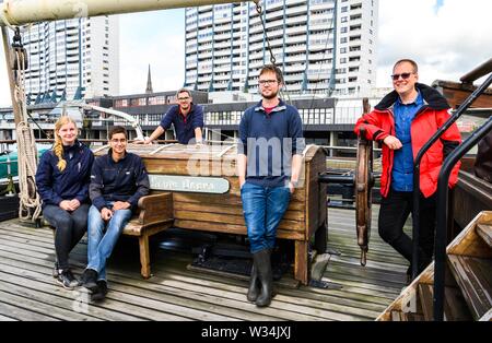 12 Juli 2019, Bremen, Bremerhaven: Kimberly Henschke (L-R), Student der maritimen Technologien an der Hochschule Bremerhaven, Andreas Bauhammer, Student der maritimen Technologien der Hochschule Bremerhaven, Lars Kröger, dem Project Manager eute Deern' Deutsches Schifffahrtsmuseum, Caspar Ebner, Student der maritimen Technologien der Hochschule Bremerhaven, und Jan Boelmann, Labor-Techniker für maritime Technologien der Hochschule Bremerhaven, Posieren auf der Seute Deern, ein Restaurant und Museum Schiff im Alten Hafen von Bremerhaven. Die Gruppe verwendet eine Unterwasser Roboter die con zu untersuchen Stockfoto