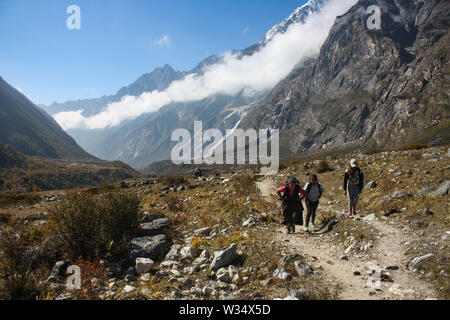 Die lokalen Menschen zu Fuß auf dem Langtang Tal durch die Berge und gepflasterten Weg. Hartes Leben aber friedlich und glücklich leben. Stockfoto