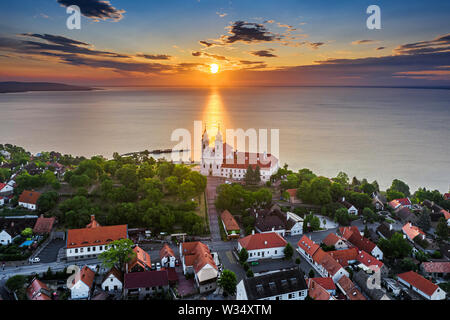 Tihany, Ungarn - Luftbild Skyline Blick auf die berühmte Benediktinerabtei Tihany (Abtei Tihany) mit schönen bunten Himmel und Wolken bei Sonnenaufgang Stockfoto