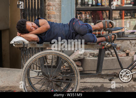 Mann schlafend auf seinem Dreirad in Kathmandu Stockfoto