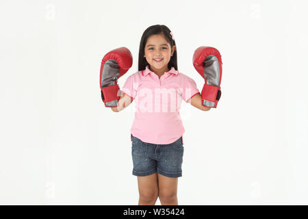 Portrait eines Mädchens, das Boxhandschuhe trägt und lächelt Stockfoto