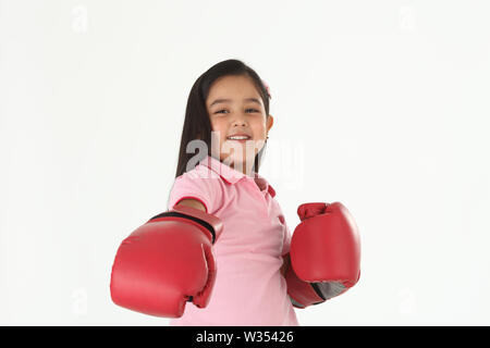 Portrait eines Mädchens, das Boxhandschuhe trägt und lächelt Stockfoto