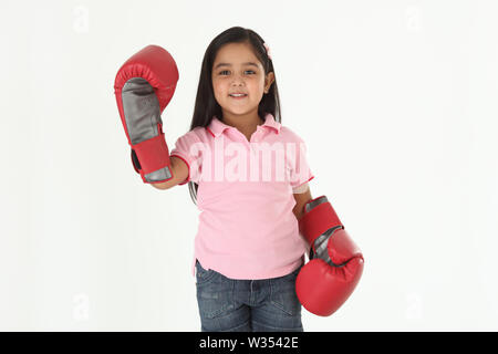 Portrait eines Mädchens, das Boxhandschuhe trägt und lächelt Stockfoto