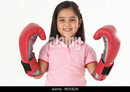 Portrait eines Mädchens, das Boxhandschuhe trägt und lächelt Stockfoto