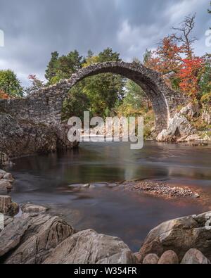 Eine alte Karre Brücke von Stein über einen Fluss in Schottland, mit einer langen Belichtungszeit genommen Stockfoto