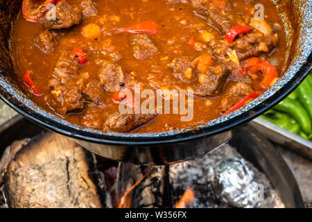 Bereit Kesselgulasch nach vier Stunden Kochen über offenem Feuer. Mit Tomaten, Rindfleisch, Zwiebeln, Knoblauch, Sellerie und Karotten. Stockfoto