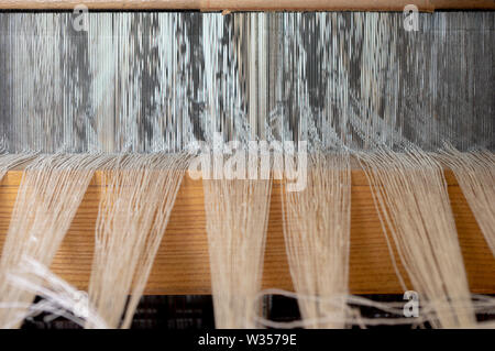 Leinen Garn durch die Reed aus einer Hand Webstuhl Stockfoto