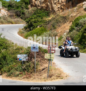 Kreta, Griechenland. Juni 2019. Paar reiten ein Quad auf einem Feldweg bei Rodopos in der Nähe von Kissamos, Kreta, Stockfoto