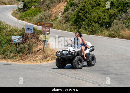 Kreta, Griechenland. Juni 2019. Paar reiten ein Quad auf einem Feldweg bei Rodopos in der Nähe von Kissamos, Kreta, Stockfoto