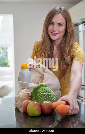 Portrait von Frau Heimweg von Shopping Trip Auspacken Kunststoff Kostenlose Einkaufstaschen Stockfoto