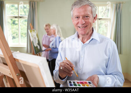 Portrait von älteren Menschen an Malerei Klasse mit Lehrer im Hintergrund Stockfoto