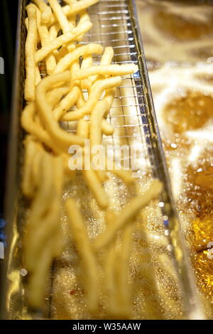 Fast Food, Pommes Frites in der Friteuse auf lokaler Nacht Markt Stockfoto