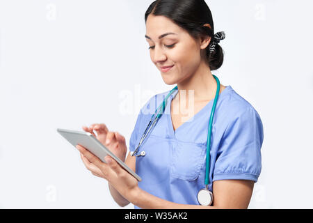 Studio Shot der weiblichen Krankenschwester tragen Peelings mit digitalen Tablet Stockfoto