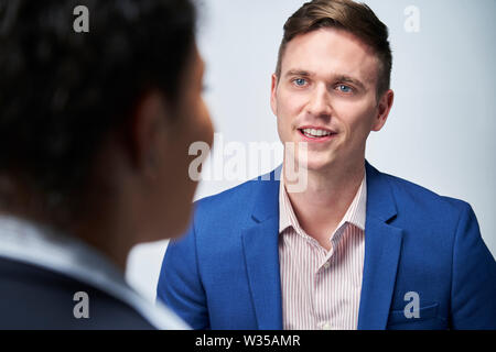 Studio Shot der Geschäftsmann interviewen Geschäftsfrau für Beschäftigung vor weißem Hintergrund Stockfoto