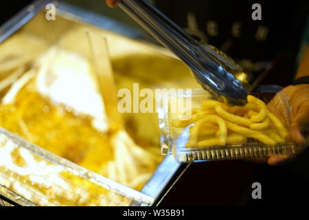 Fast Food, Pommes Frites in der Friteuse auf lokaler Nacht Markt Stockfoto