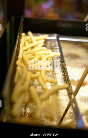 Fast Food, Pommes Frites in der Friteuse auf lokaler Nacht Markt Stockfoto