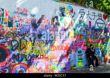 Prag, Tschechische Republik - 27 Juni 2019: Asiatische Paar während der Hochzeit Fotoshooting vor der berühmten John Lennon Mauer in der tschechischen Hauptstadt. Graffiti Wall von berühmten Künstler inspiriert. Beliebte touristische Ort. Stockfoto