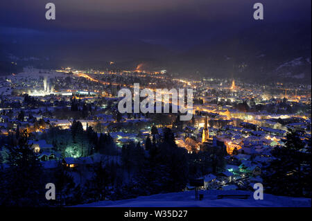 Beleuchtete Stadt Garmisch-Partenkirchen bei kalten Winternacht Stockfoto