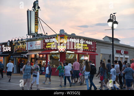 OCEAN CITY, New Jersey/USA - Juni 27, 2019: Touristen und Geschäftsreisende, die essensstände und Spielhallen auf der Ocean City Boardwalk bei Sonnenuntergang Stockfoto