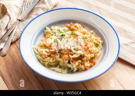 Cremige gebackene Chicken Alfredo mit spaghetti Pasta überbacken mit Parmesan und Mozzarella Käse und Panko Paniermehl Stockfoto