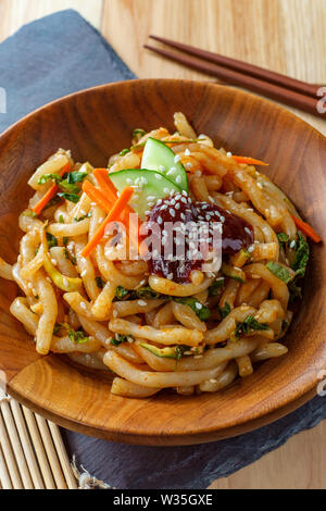 Wokgemüse kimchi Udon Noodle bokkeum mit frischen Kirby Gurken Karotten und gochujang suace Stockfoto