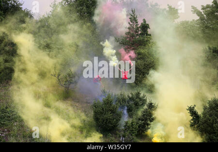 Hardheim, Deutschland. 12. Juli, 2019. Fussball: Test Matches, FC Schweinberg - Borussia Dortmund. Vor dem Spiel außerhalb des Stadions, Fußball Fans Licht bengalischen Feuern in Rot und Gelb. Foto: Karl-Josef Hildenbrand/dpa/Alamy leben Nachrichten Stockfoto