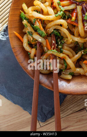 Wokgemüse kimchi Udon Noodle bokkeum mit frischen Kirby Gurken Karotten und gochujang suace Stockfoto