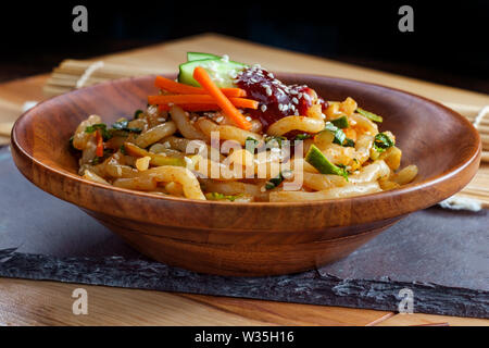 Wokgemüse kimchi Udon Noodle bokkeum mit frischen Kirby Gurken Karotten und gochujang suace Stockfoto