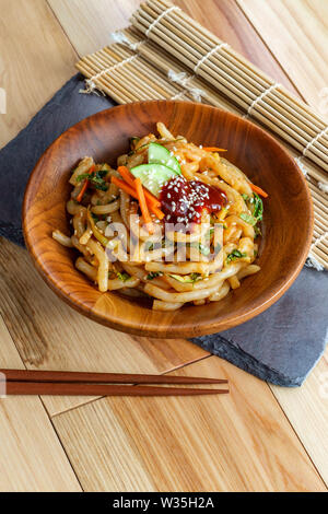 Wokgemüse kimchi Udon Noodle bokkeum mit frischen Kirby Gurken Karotten und gochujang suace Stockfoto