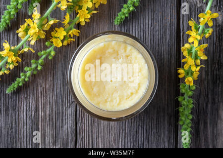 Ein Glas hausgemachte Salbe vom Shea Butter und frischem agrimony Blumen, Ansicht von oben Stockfoto