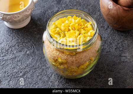 Zubereitung von hausgemachten Kräuter Sirup gegen Husten aus frischen denseflower Königskerze Blüten und Rohrzucker Stockfoto