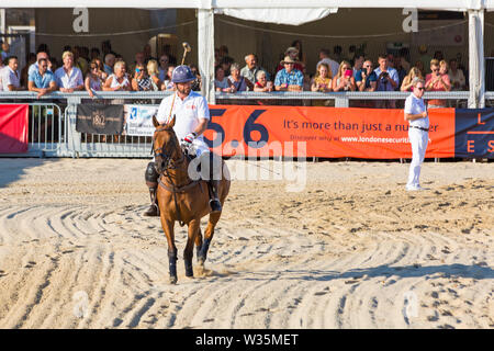 Sandbänke, Poole, Dorset, Großbritannien, 12. Juli 2019. Die Sandpolo britische Beach Polo Meisterschaften erhält unterwegs bei Sandbanks Beach, Poole an einem warmen sonnigen Tag. Der größte Strand Polo Event in der Welt, die zweitägige Veranstaltung findet am Freitag und Samstag statt, die Besucher des Beach Head der Aktion zu sehen. Nick Knowles nimmt Teil an einen Elfmeter schießen mit Harry Redknapp commentating und Überwachung. Credit: Carolyn Jenkins/Alamy leben Nachrichten Stockfoto