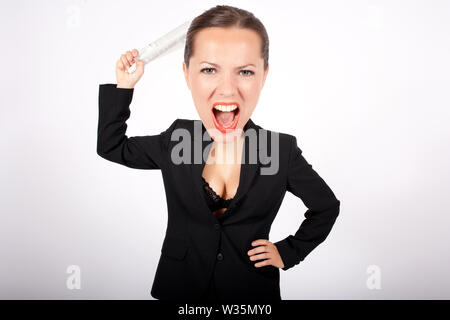 Wütende Frau in Anzug mit großen Kopf mit einer aufgerollten Zeitung Stockfoto
