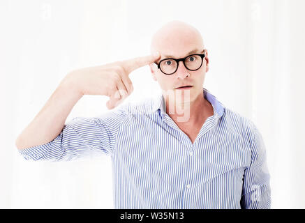 Portrait von umgekippt Geschäftsmann mit großen Kopf auf seinen Finger zu Kopf Stockfoto