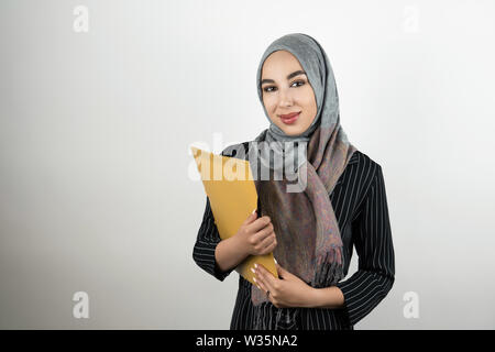 Junge schöne Muslimischen business Frau mit Turban hijab Kopftuch Ordner mit Dokumenten isoliert weißer Hintergrund Stockfoto