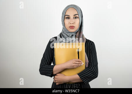 Junge schöne Muslimischen business Frau mit Turban hijab Kopftuch Ordner mit Dokumenten und Pen isoliert weißer Hintergrund Stockfoto