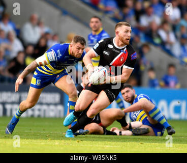 Warrington, Cheshire, UK. 12. Juli, 2019. RFL Rugby League, Warrington Wolves versus Salford Roten Teufel; Jackson Hastings von Salford Roten Teufel sucht einen Pass beim Versuch, um zu vermeiden, dass die von Daryl Clark von Warrington Wolves Credit: Aktion plus Sport/Alamy Leben Nachrichten anpacken Stockfoto