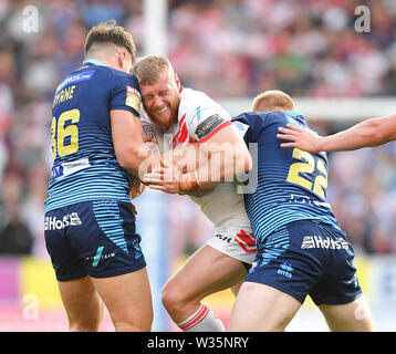 St. Helens' Luke Thompson ist von Wigan Warriors' Liam Byrne und Morgan Schmieden während der Super League Match an der völlig Gottlosen Stadion, St Helens angegangen. Stockfoto