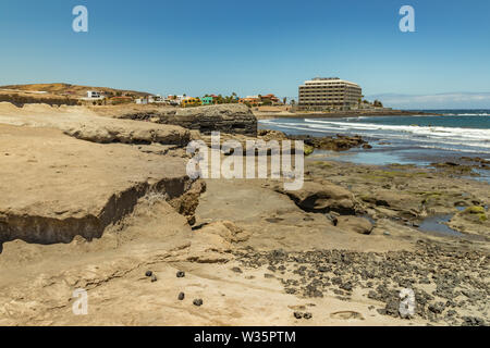 Panoramablick auf die Südküste von El Medano. Alte militärische Bunker in der Mitte und Sandstrand mit Menschen baden im Hintergrund. Teneriffa Kana Stockfoto