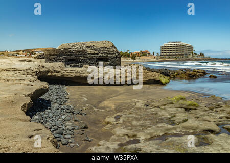 Panoramablick auf die Südküste von El Medano. Alte militärische Bunker in der Mitte und Sandstrand mit Menschen baden im Hintergrund. Teneriffa Kana Stockfoto