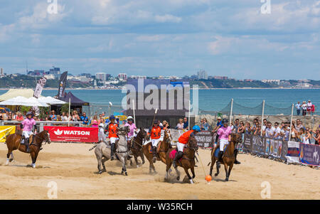 Sandbänke, Poole, Dorset, Großbritannien, 12. Juli 2019. Die Sandpolo britische Beach Polo Meisterschaften erhält unterwegs bei Sandbanks Beach, Poole an einem warmen sonnigen Tag. Der größte Strand Polo Event in der Welt, die zweitägige Veranstaltung findet am Freitag und Samstag statt, die Besucher des Beach Head der Aktion zu sehen. Credit: Carolyn Jenkins/Alamy leben Nachrichten Stockfoto