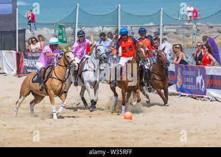 Sandbänke, Poole, Dorset, Großbritannien, 12. Juli 2019. Die Sandpolo britische Beach Polo Meisterschaften erhält unterwegs bei Sandbanks Beach, Poole an einem warmen sonnigen Tag. Der größte Strand Polo Event in der Welt, die zweitägige Veranstaltung findet am Freitag und Samstag statt, die Besucher des Beach Head der Aktion zu sehen. Credit: Carolyn Jenkins/Alamy leben Nachrichten Stockfoto