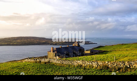 Grüne Felder und Häuser an der Küste, Küste und Inseln in einem Abstand, Moody dunklen Himmel mit stürmischen Wolken, Wiled Atlantic Art, Irland Stockfoto