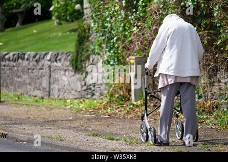 Arran, North Ayrshire/Schottland - 10 Juli 2019: Senior Senioren gefährdete Person mit Walking Gehhilfe für Mobilität in abgelegenen Landschaft Stockfoto