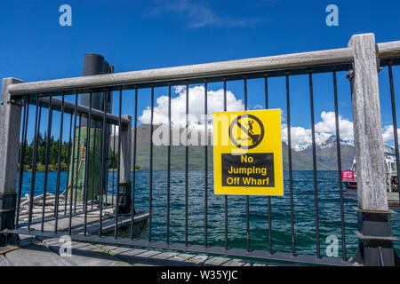 Keine springen Zeichen auf Queenstown Wharf am Ufer des Lake Wakatipu mit Bergen im Hintergrund, Queenstown, Südinsel Neuseeland Stockfoto